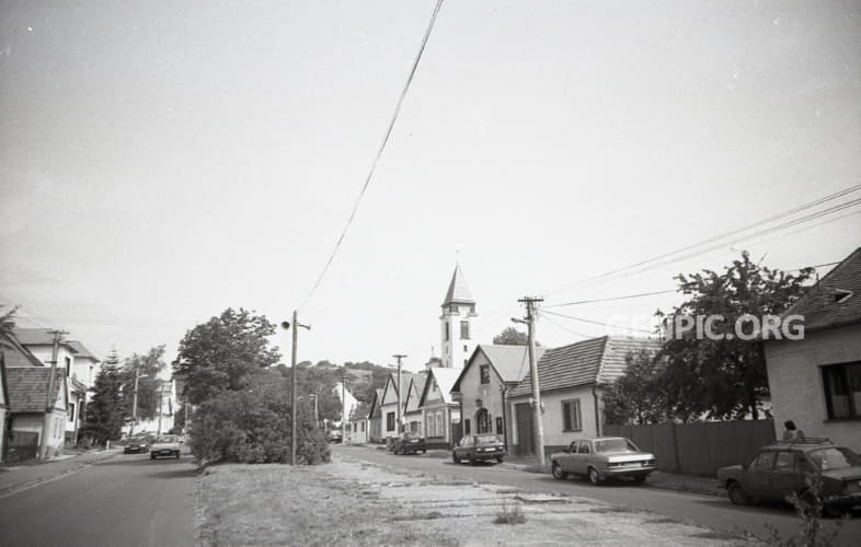 Street - Typical houses. St. Margaret Roman Catholic Parish Church on the background.